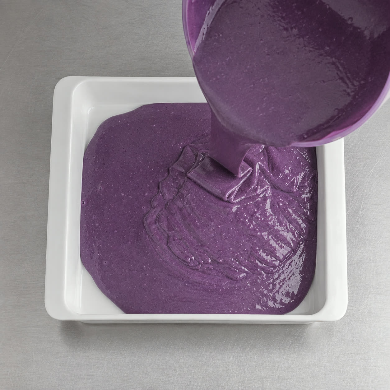 Impasto viola della torta all'ube versato nella teglia, pronto per il forno | Ube Nolia