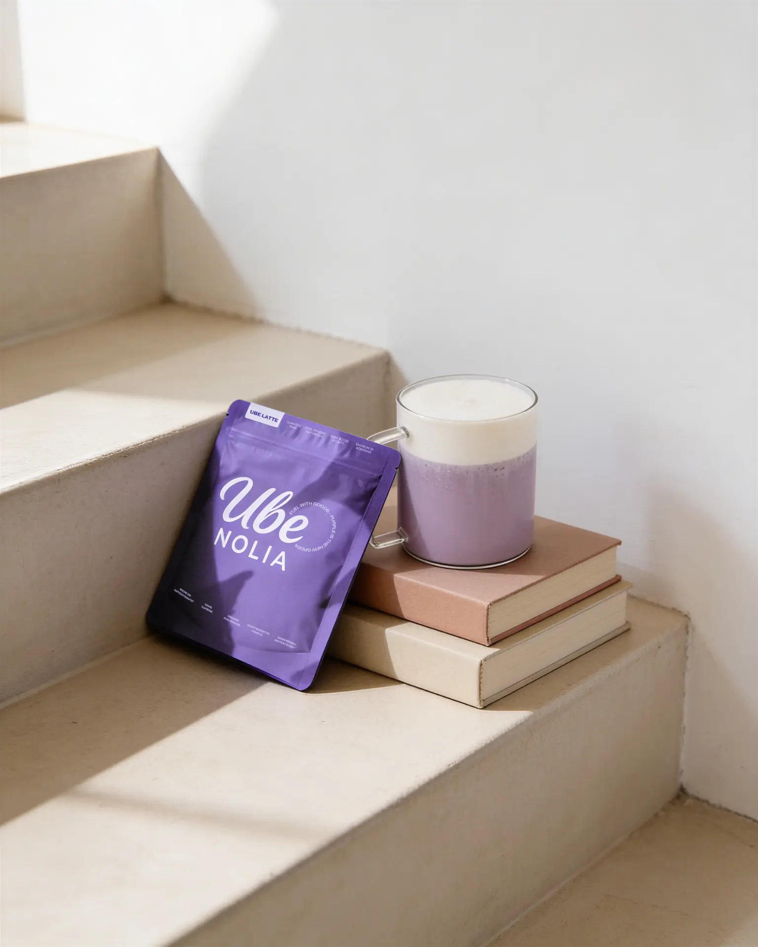 Ube Nolia ube powder pouch next to a creamy ube latte on beige stairs | Ube Nolia