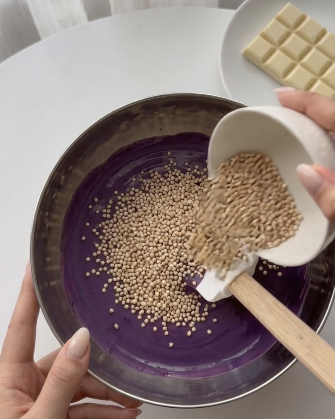 Folding puffed quinoa into ube white chocolate for Ube Nolia quinoa bites