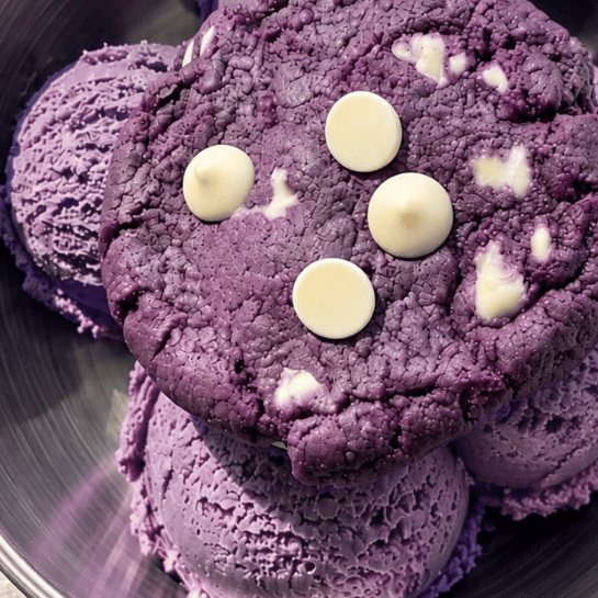 The ultimate ube ice cream cookie: a scoop of purple yam (ube) coconut ice cream in a bowl with a soft ube white chocolate cookie on top, a Filipino-inspired dessert made with Ube Nolia <a href='/products/ube-latte-powder'>ube powder</a>