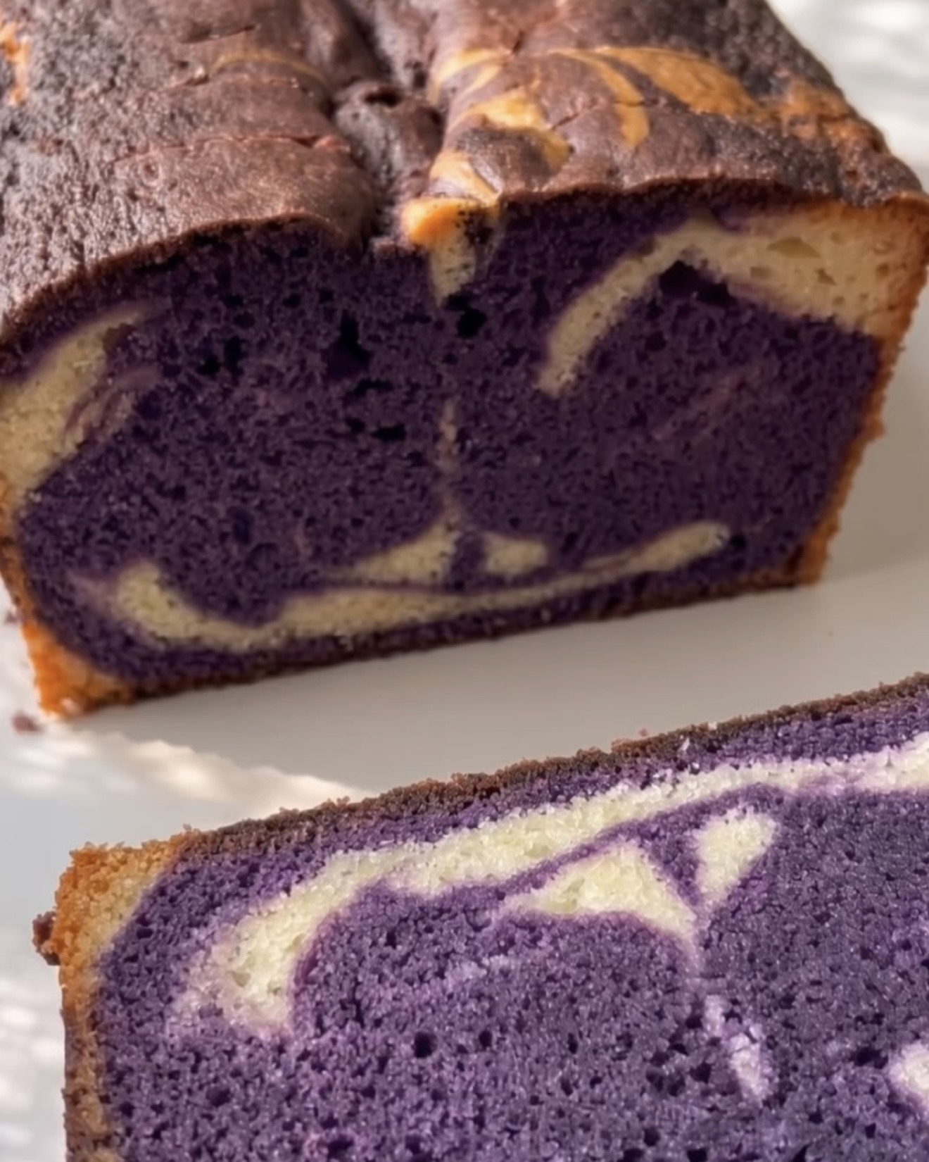 Baked ube marble pound cake cut open showing the purple and vanilla swirl, made with Ube Nolia ube powder