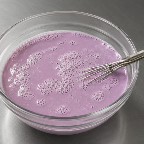 Miscela di latti all'ube viola montata in una ciotola di vetro | Ube Nolia