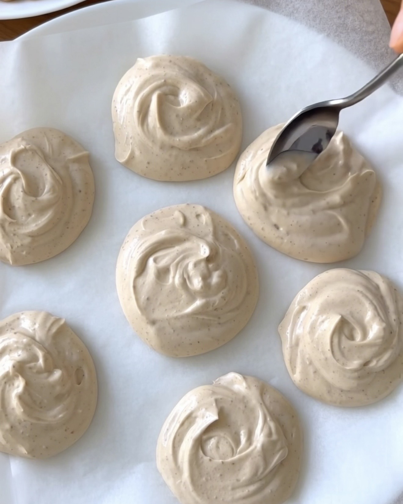 Porciones de yogur griego con mantequilla de cacahuete cremosas sobre papel de horno para los bocaditos congelados de ube de UBE NOLIA