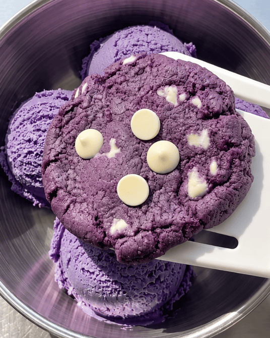 Ube white chocolate cookie resting on scoops of ube ice cream, purple yam | Ube Nolia