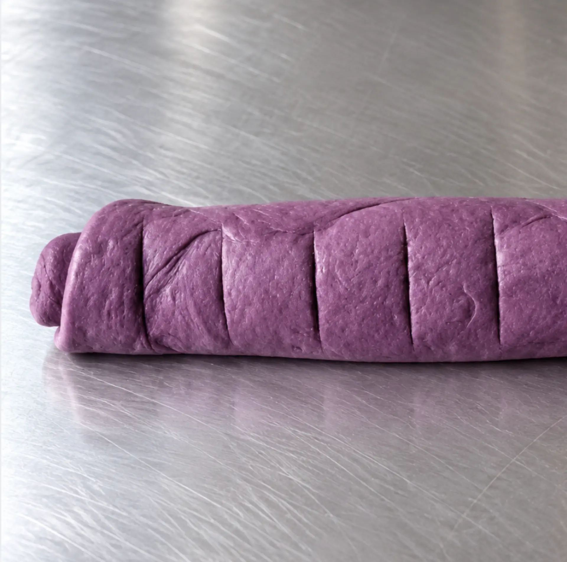 Ube Nolia ube powder brioche dough with cinnamon filling, cut into 12 cinnamon rolls
