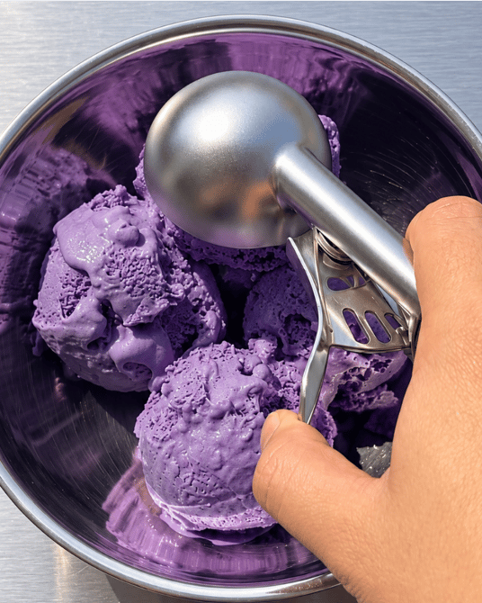 Scooping ube ice cream with a metal ice cream scoop, purple yam | Ube Nolia
