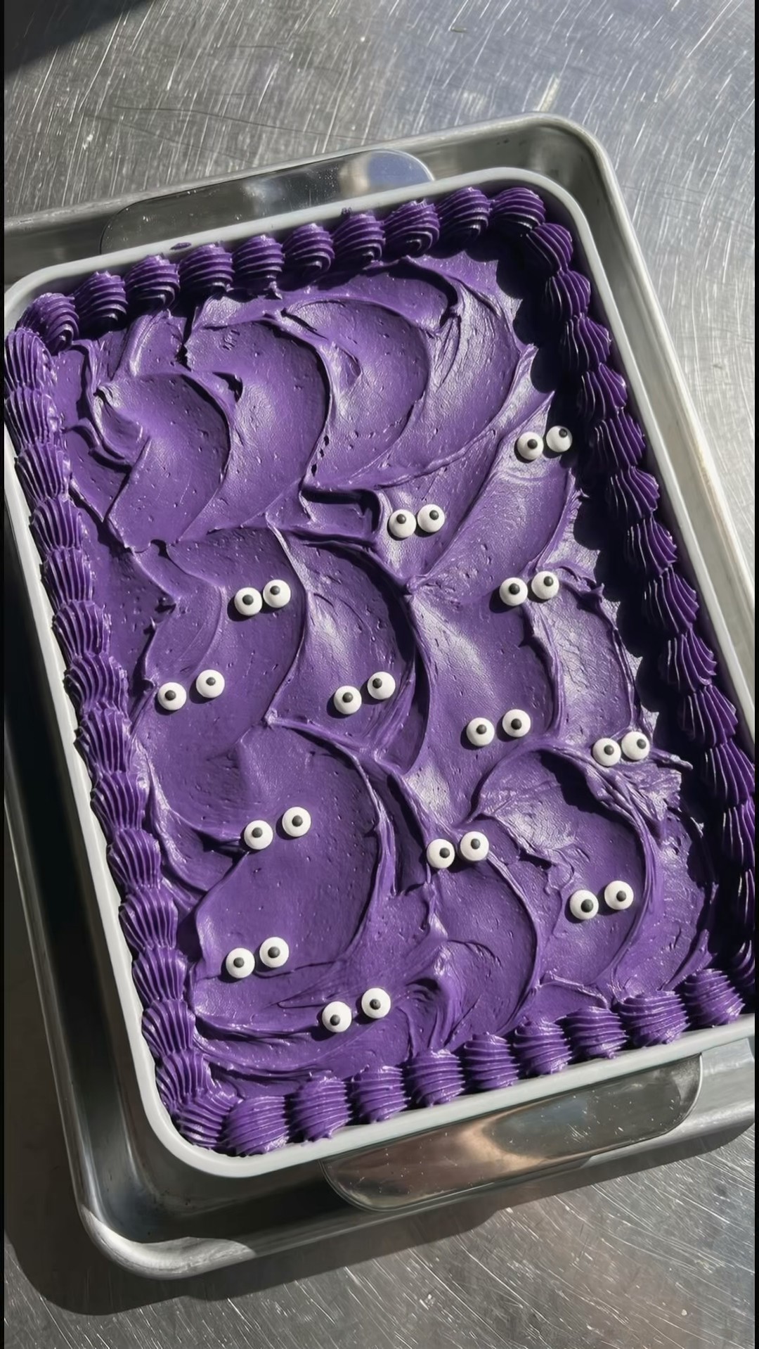 Halloween cake with purple ube frosting decorated with white and black fondant eyes by Ube Nolia