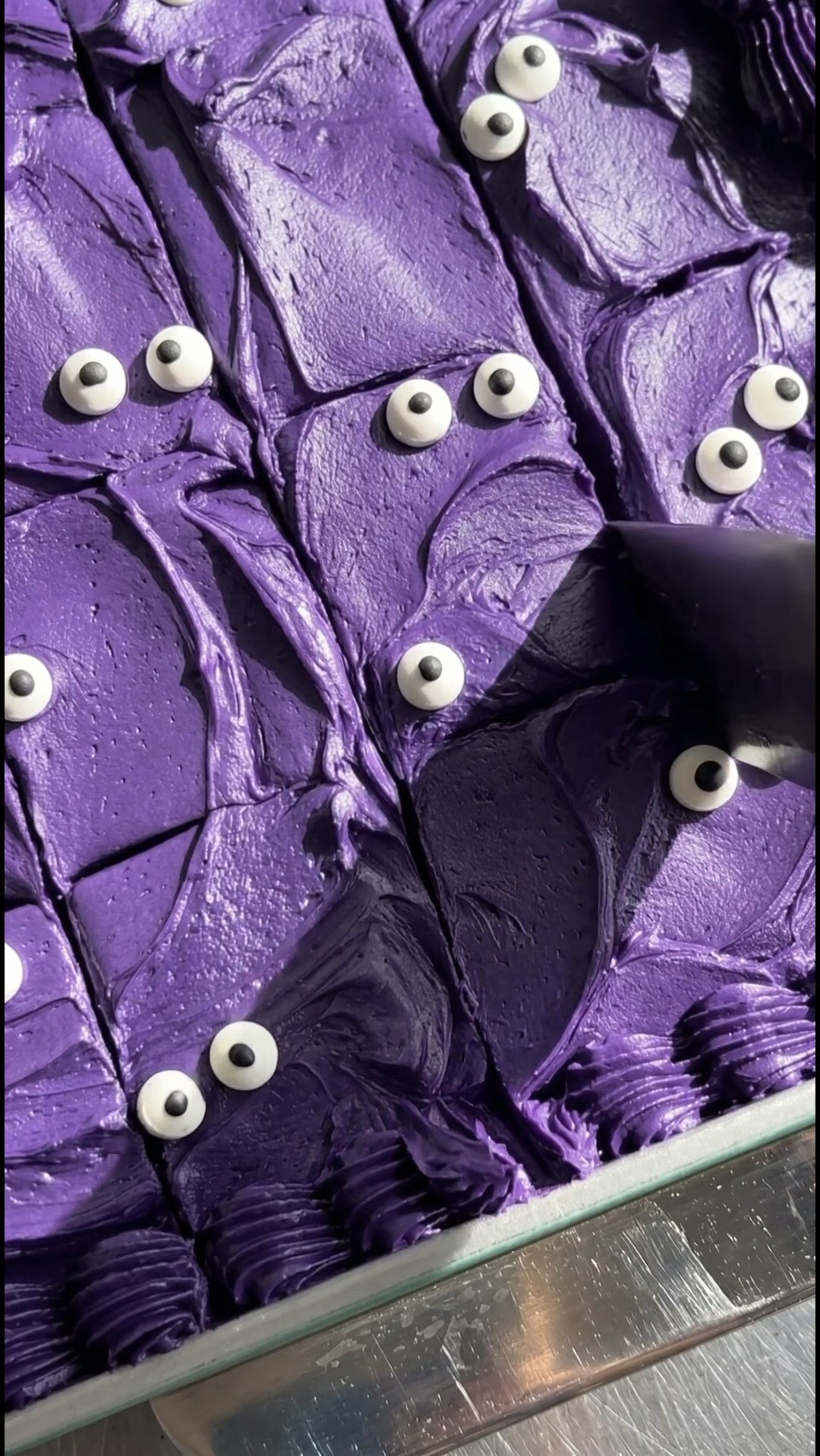Sliced Halloween cake in a baking pan with a cake server lifting out a square by Ube Nolia