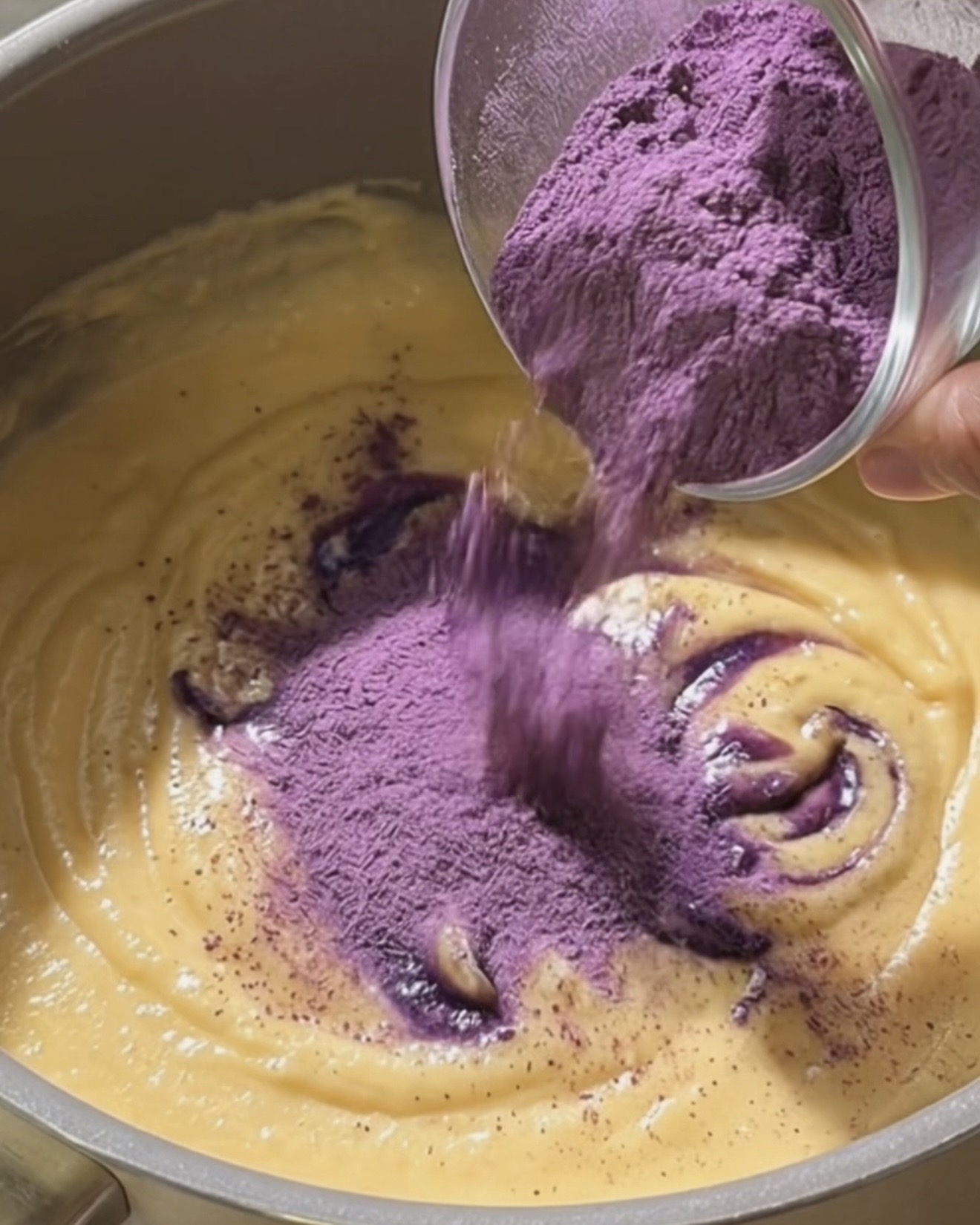 Vispa Ube Nolia ubepulver i kokos- och kondenserad mjölk för att göra ube halaya-fyllning till dadar gulung