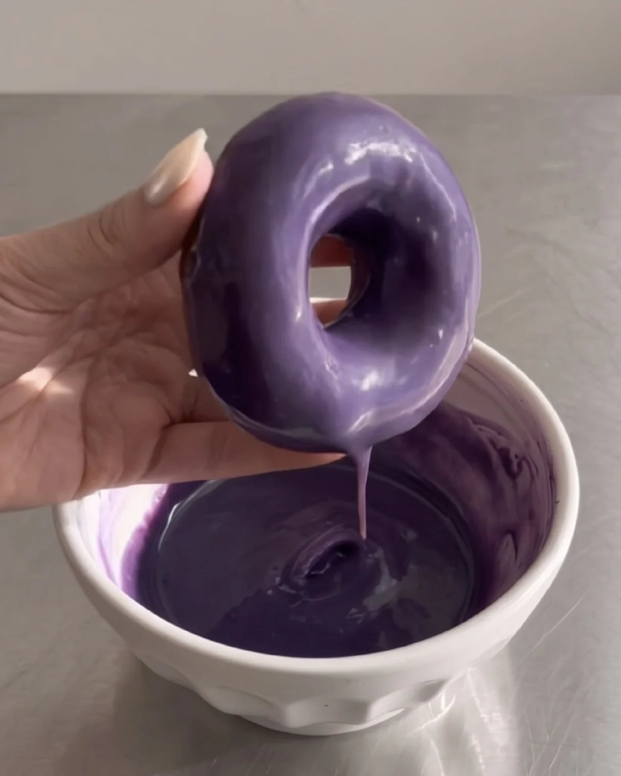 Dipping a baked ube donut into purple ube glaze | Ube Nolia