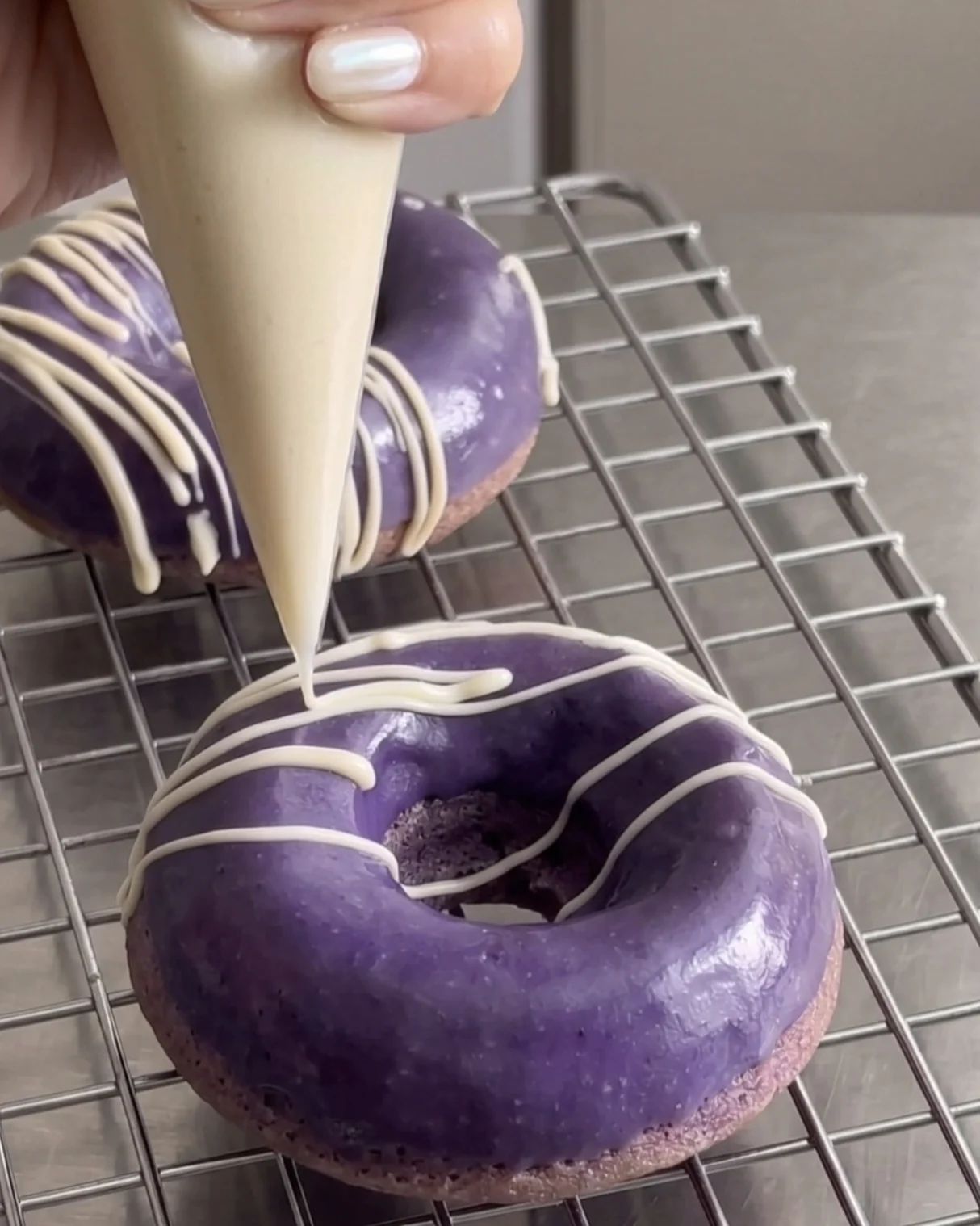 White chocolate drizzle over purple ube glazed donuts | Ube Nolia