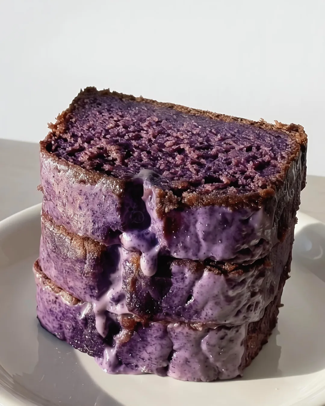 Sliced ube banana bread loaf with purple ube glaze | Ube Nolia ube recipe